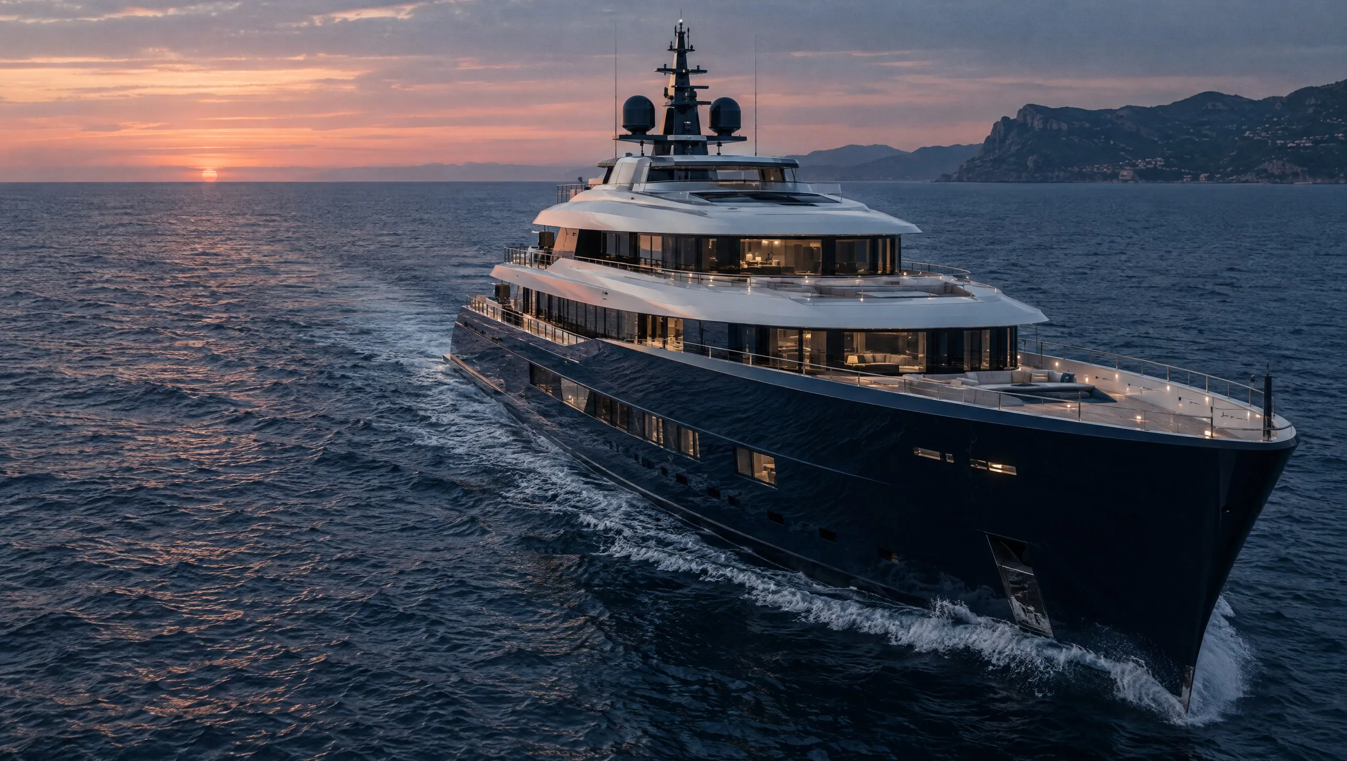 A modern motor superyacht under way at dusk